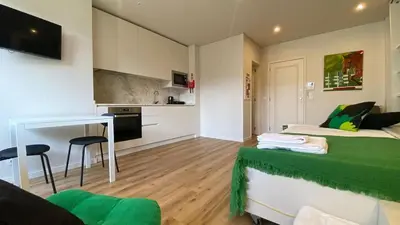 a small room with two beds and a kitchen at BEST - Studio Trindade with AC and Parking in Porto