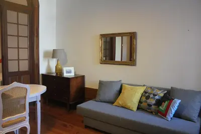 a living room with a blue couch and a mirror at Downtown Classic Apartment in Porto