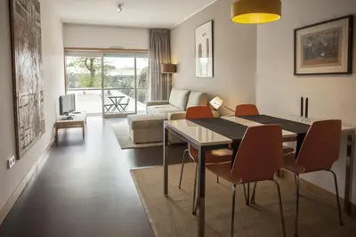 a living room with a table and chairs and a couch at Casa do Sol in Porto