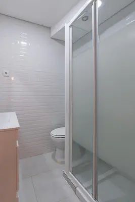 a bathroom with a toilet and a glass shower at HostWise - Artistic Escape with Modern Comfort in Vila Nova de Gaia