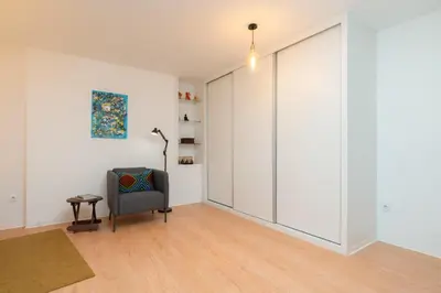 a sliding door in a room with a chair at HostWise - Artistic Escape with Modern Comfort in Vila Nova de Gaia
