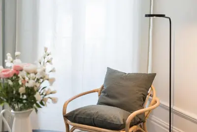 a chair with a pillow and a vase of flowers at GuestReady - Visconde Mezzanine in Porto