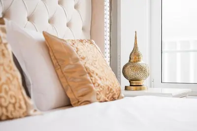 a white bed with pillows and a vase on a table at GuestReady - Boutique style loft in Constitution in Porto