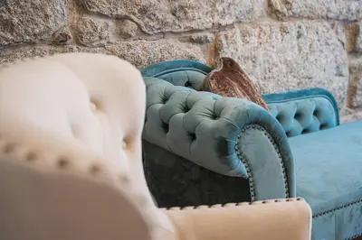 a blue couch sitting next to a stone wall at GuestReady - Boutique style loft in Constitution in Porto