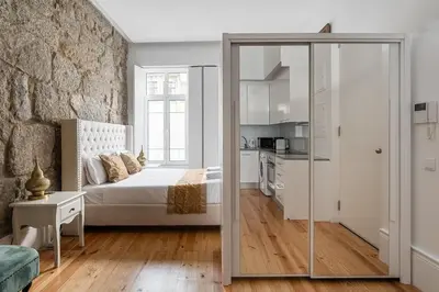 a bedroom with a bed and a glass door leading to a kitchen at GuestReady - Boutique style loft in Constitution in Porto