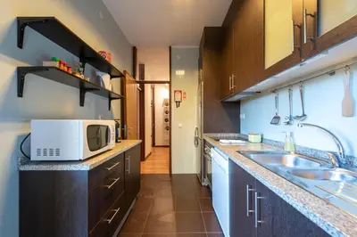 a small kitchen with a microwave and a sink at Botanic Jungle at Porto Downtown in Porto