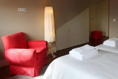 a room with a red chair and a bed at Porto with History in Porto