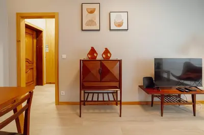 a living room with a tv and a table at Good Morning Torrinha by Vacationy in Porto