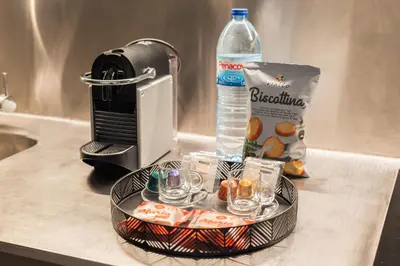 a bottle of water and a plate with cups and a drink at The Luxe Cube Apartment in Porto