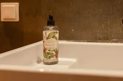 a bottle of alcohol sitting on top of a bath tub at The Luxe Cube Apartment in Porto