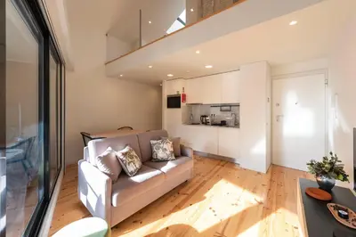 a living room with a couch and a kitchen at Porto Luxe Stay with shared Pool and Garden in Porto