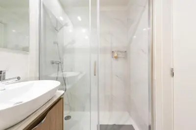 a white bathroom with a shower and a sink at Porto Luxe Stay with shared Pool and Garden in Porto