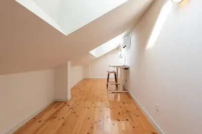 an attic room with a desk and a white ceiling at Porto Luxe Stay with shared Pool and Garden in Porto