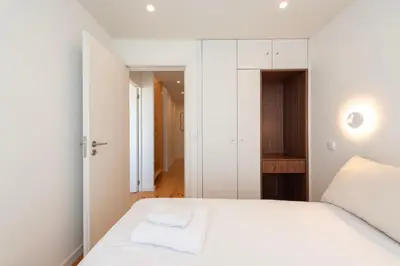 a white bedroom with a bed and a mirror at Porto Luxe Stay with shared Pool and Garden in Porto