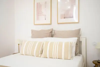 a bedroom with a white bed with two pictures on the wall at Chic 1BR in República w Balcony by LovelyStay in Porto