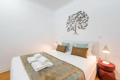 a bedroom with a white bed with towels on it at GuestReady - The Citrus Glaze at the Terrace in Porto