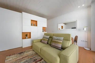 a living room with a couch and a mirror at GuestReady - The Citrus Glaze at the Terrace in Porto