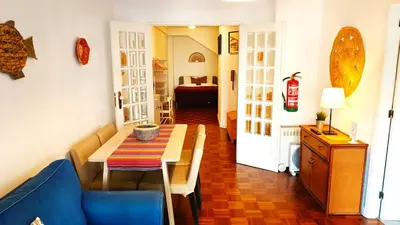 a dining room with a table and a blue couch at Porto Downtown in Porto