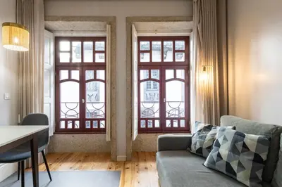 a living room with two windows and a couch at ApartmentsPorto - Rua de Trás 156 in Porto