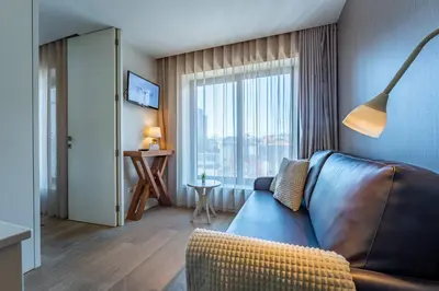 a living room with a couch and a large window at Bellevue Oporto Downtown in Porto