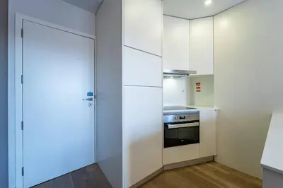 a kitchen with white cabinets and a stove at Bellevue Oporto Downtown in Porto