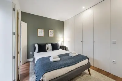 a bedroom with a large bed with a blue blanket at GuestReady - Restful haven in Porto in Porto