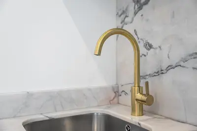 a kitchen sink with a gold kitchen faucet at GuestReady - Restful haven in Porto in Porto