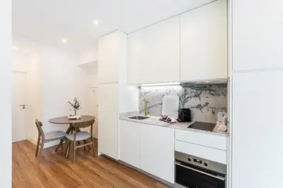 a kitchen with white cabinets and a small table at GuestReady - Restful haven in Porto in Porto
