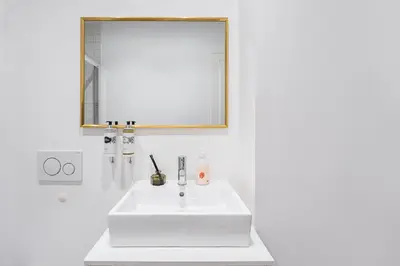 a white bathroom with a sink and a mirror at GuestReady - Restful haven in Porto in Porto