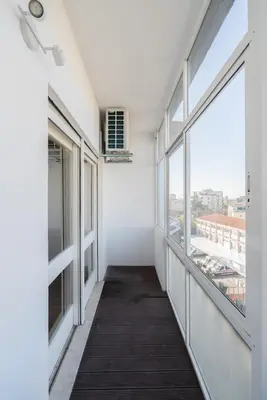 an empty hallway with large windows in a building at Bright & Spacious Retreat with Balcony by HostWise in Porto