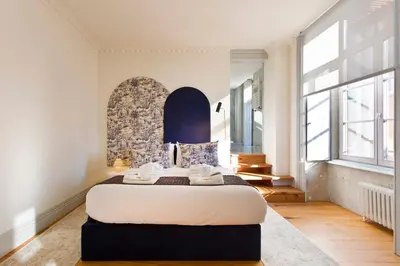 a bedroom with a large bed in a room with windows at BOUTiQUE Rentals- THE MiRaDOURO Ribeira Apartment in Porto