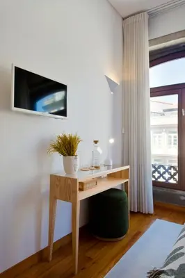 a wooden desk in a room with a tv on a wall at Boutique Rentals-SãO bEnTo Ribeira Apt in Porto