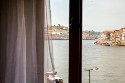 a window with a view of a river and buildings at T3 suites com vistas rio Douro in Vila Nova de Gaia