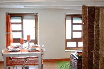 a dining room with a table and two windows at Estúdio com vistas rio Douro in Vila Nova de Gaia