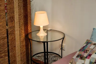 a lamp sitting on a glass table next to a bed at Estúdio com vistas rio Douro in Vila Nova de Gaia