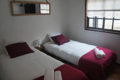 a bedroom with two beds and a mirror on the wall at Casa no centro histórico in Vila Nova de Gaia