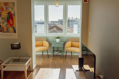 a living room with two chairs and a table and windows at Bright Deluxe by Hosty in Porto