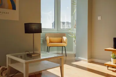 a living room with a glass table and a chair at Bright Deluxe by Hosty in Porto