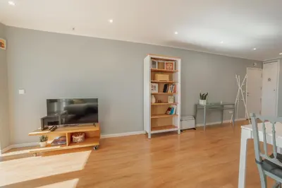 a living room with a tv and a book shelf at Bright Deluxe by Hosty in Porto