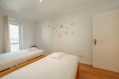 two beds in a white room with a window at Bright Deluxe by Hosty in Porto