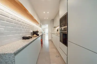 a kitchen with white cabinets and a counter top at Bright Deluxe by Hosty in Porto