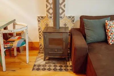 a living room with a wood stove and a couch at Historical Duplex by Hosty in Porto