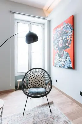 a black chair in a room with a painting at Batalha Charming Loft in Porto