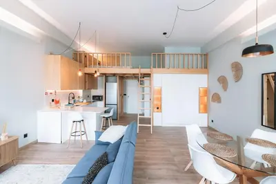 a living room with a blue couch and a kitchen at Batalha Charming Loft in Porto