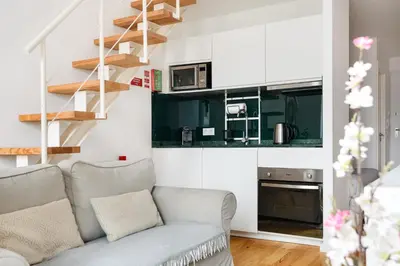 a living room with a couch and a kitchen at Mezzanine Studio in the City Center in Porto