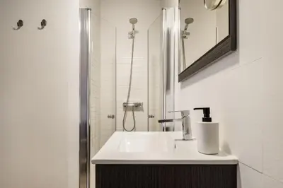 a white bathroom with a sink and a shower at Mezzanine Studio in the City Center in Porto
