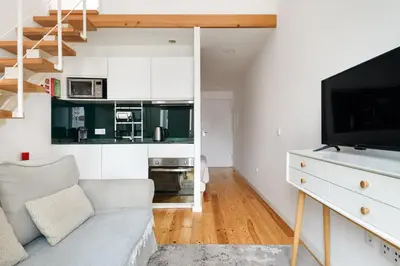 a living room with a couch and a tv at Mezzanine Studio in the City Center in Porto