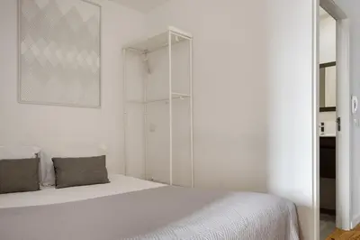 a white bedroom with a bed and a glass closet at Mezzanine Studio in the City Center in Porto