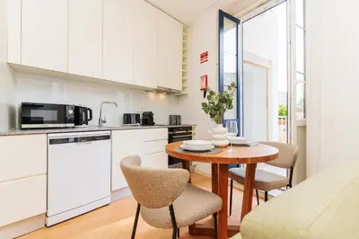 a kitchen with a table and chairs in a room at Charming Studio w/ Private Garden in St. Catarina in Porto