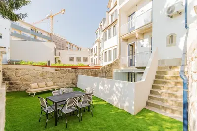 a patio with chairs and a table on the grass at Charming Studio w/ Private Garden in St. Catarina in Porto